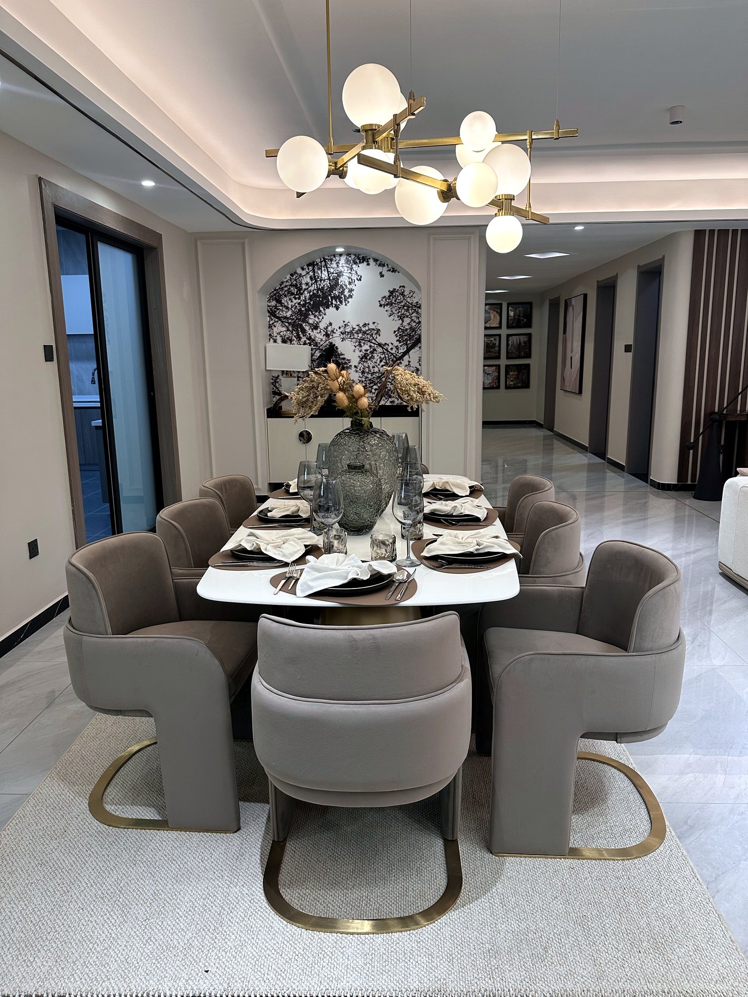 A dining room with a sculptural brass chandelier