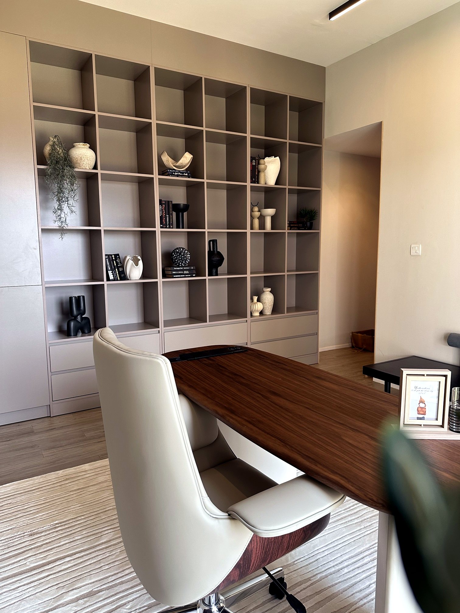 A home office with a built-in display shelving wall